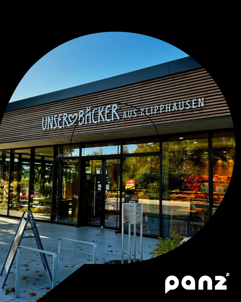 En schönes Gebäude mit holzaplikationen und großen Fensterfronten, mit der aufchrift "Unser Bäcker aus Klipphausen"